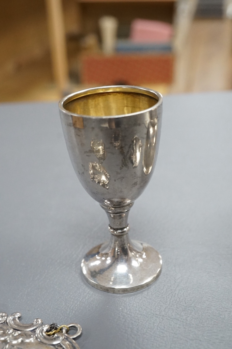 A modern silver wine funnel, with shell thumbpiece, L.J. Millington, Birmingham, 2000, 13.4cm, together with a small silver pedestal cup, three assorted sterling wine labels and three other wine labels including two plat